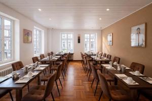 a row of tables in a room with windows at Stadthotel Jülich in Jülich