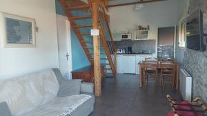 a living room with a staircase and a kitchen at Gîte nature et spa in Saint-Sulpice