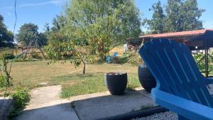 a blue bench next to a park with a playground at Gîte nature et spa in Saint-Sulpice +5 photos