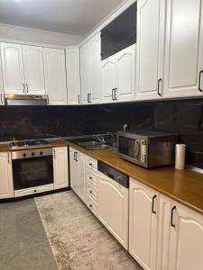a kitchen with white cabinets and a microwave at Iceland Apartment in Tirana