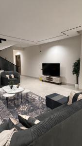 a living room with a couch and a tv at قوت in Abha
