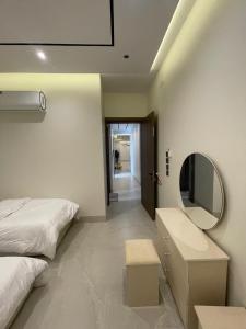 a bedroom with a bed and a mirror on the wall at قوت in Abha