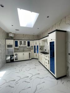a large kitchen with white cabinets and a skylight at قوت in Abha