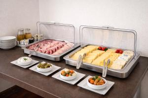 a buffet with meats and cheese and vegetables on a counter at Stadthotel Jülich in Jülich +12 photos