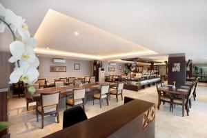 a dining room with tables and chairs and a restaurant at 1O1 URBAN Heritage Yogyakarta Lynn Prawirotaman in Yogyakarta