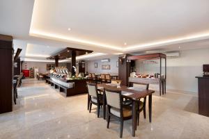 a restaurant with tables and chairs and a buffet at 1O1 URBAN Heritage Yogyakarta Lynn Prawirotaman in Yogyakarta +47 photos