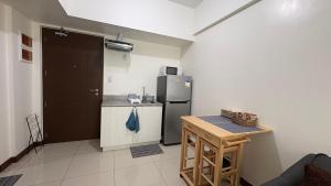 a kitchen with a refrigerator and a table in it at Peppers Crib in Manila