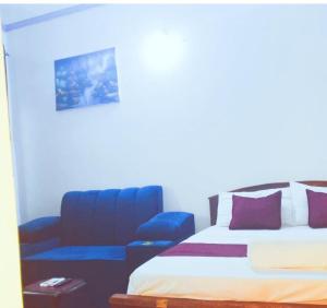 a bedroom with a bed and a blue chair at kandys place in Watamu