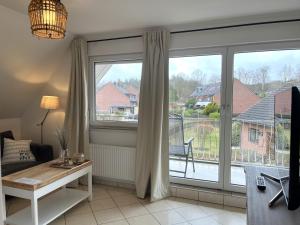 a living room with a large window and a table at Ferienhaus Haffliebe in Scharbeutz
