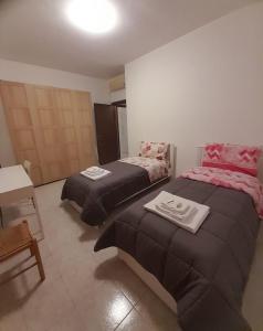 a room with two beds and a table in it at Casa Pirandello 3 min Metro in Sesto San Giovanni