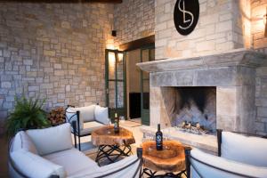 a fireplace in a living room with white couches and chairs at Viñedos San Lucas in San Miguel de Allende