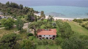 an aerial view of a house on a hill next to a beach at Hacienda Beachfront Villa, Spathies in Nikiti +71 photos