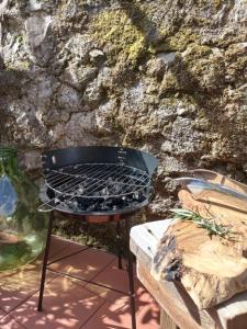 a grill on a table next to a stone wall at La Voltina in Diecimo