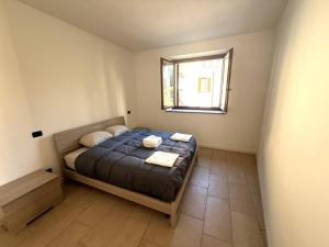 a small bedroom with a bed and a window at Casa ajolote in Cunardo
