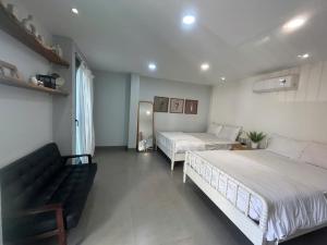 a bedroom with two beds and a couch in it at Lemon House in Quy Nhon