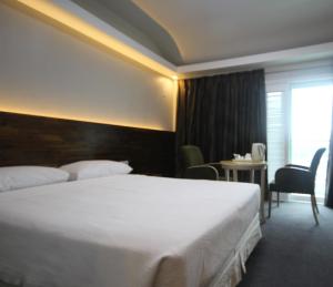 una habitación de hotel con una cama grande y una mesa en Hotel Ocean View, en Ulsan