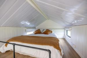 a bedroom with a bed in the middle of a room at Echidna by Tiny Away in Thoopara