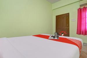 a bedroom with a bed with a red and white blanket at Hotel O Ss Delight in Hyderabad