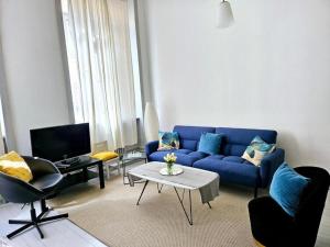 a living room with a blue couch and a table at Le Canut Duviard - proche métro Croix-Rousse in Lyon