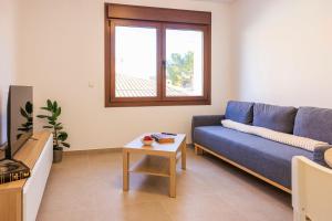 a living room with a blue couch and a table at Apartamentos Turísticos Olivares in Mota del Cuervo