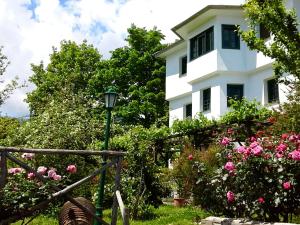 a white house with pink flowers in front of it at Pepromeno Boutique in Agios Dimitrios