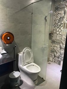 a bathroom with a toilet and a glass shower at Lemon House in Quy Nhon