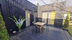 a wooden deck with a table and chairs on it at Jomas & Baltic beach in Jūrmala