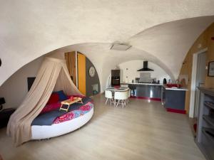 a bedroom with a bed with a canopy and a kitchen at Les Gîtes de Chauvet in Gap