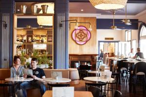 two people sitting at tables in a restaurant at The Rose Hotel & Motel in Bunbury