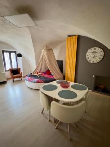 a room with a table and chairs and a bed at Les Gîtes de Chauvet in Gap