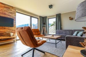 a living room with a couch and a chair at UplandParcs Bergblick in Winterberg