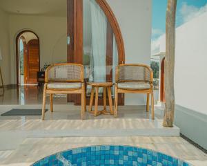 two chairs and a table in a house at Star Hill Kintamani in Kubupenlokan
