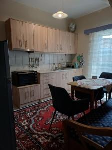 a kitchen with wooden cabinets and a table with chairs at "ΑΡΜΟΝΊΑ" ΔΙΑΜΕΡΙΣΜΑ, ΚΑΛΑΜΑΤΑ-"HARMONY" apartment, Kalamata in Kalamata