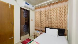 a bedroom with a white bed and a window at Hotel Labbaik Three College Gate in Dhaka