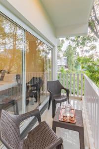 a balcony with two chairs and a table with a tray at Riyan Valley Resort in Ooty