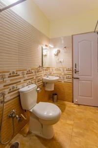 a bathroom with a toilet and a sink at Riyan Valley Resort in Ooty +55 photos