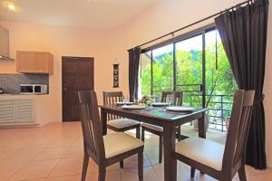 una cucina e una sala da pranzo con tavolo e sedie di Soleil D'asie Residence a Chaweng Noi Beach
