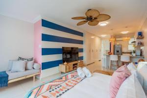 a living room with a blue and white striped wall at Alfomada in Umdloti +4 photos