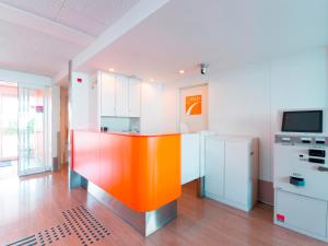 a kitchen with an orange island in the middle of a room at Chisun Inn Utsunomiya Kanuma in Utsunomiya