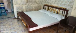 a bed with a wooden frame in a room at ADwarkesh femily homestay in Dwarka