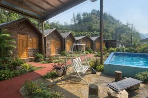 a group of wooden huts with a swimming pool at Sapa May Ecolodge in Sapa