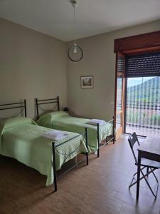 a bedroom with two beds and a window and a table at B&B Camposauro in Vitulano +17 photos