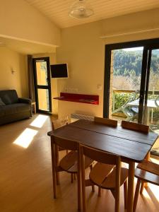 a living room with a wooden table and chairs at Domaine Aigoual Cevennes in Meyrueis