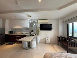 a kitchen and living room with a table and a couch at stevenplace at Tambuli in Maribago