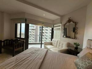 a bedroom with a bed and a couch and a mirror at stevenplace at Tambuli in Maribago +7 photos