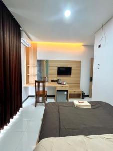 a bedroom with a bed and a desk in a room at Pangeran Residence 2 in Adi Sutjipto
