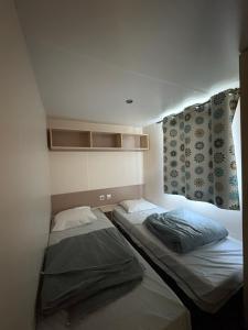 two beds in a small room with a window at Camping Arquebuse in Auxonne +144 photos