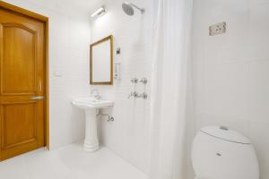 a white bathroom with a toilet and a sink at Hotel Ambience Hill Nainital - near Bhowali in Nainital +34 photos