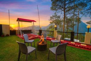 a patio with chairs and a fire pit with a view at Hotel Ambience Hill Nainital - near Bhowali in Nainital