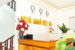 a waiting room with flowers and clocks on the wall at Việt Hà Motel in Bảo Lạc